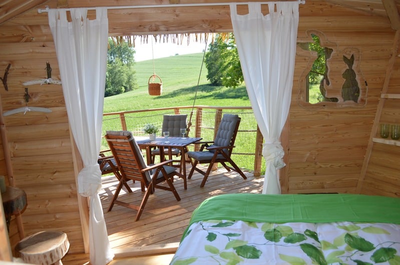 Terasa treehousu s posezením a výhledem do zeleně